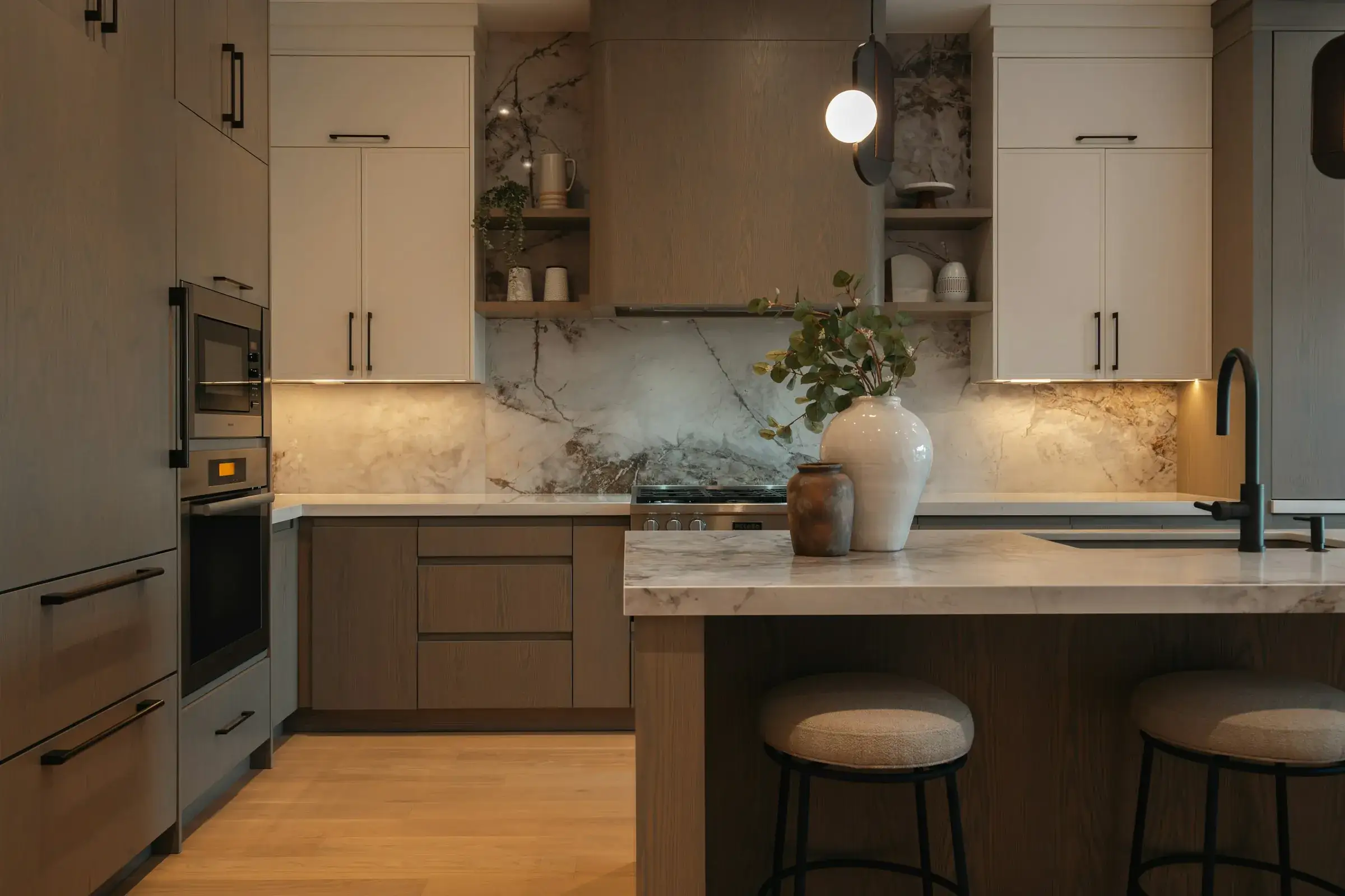 Finished kitchen with warm taupe cabinetry, a marble backsplash, an oak-panelled island with two bouclé stools and a glass pendant light.